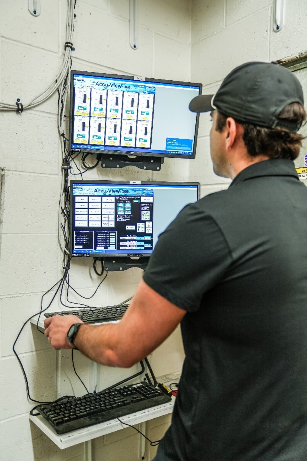 Al's Super Wash operator monitoring the wash control system on dual screens