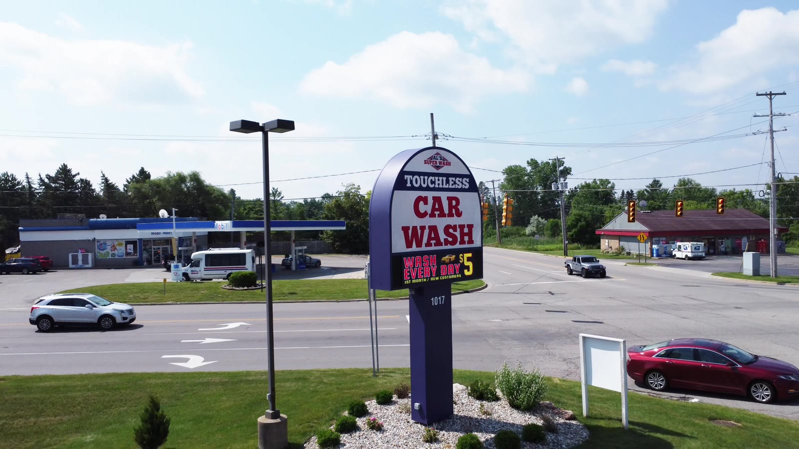 Al's Super Wash touchless car wash sign on Dort Hwy advertising $5 first month for new customers