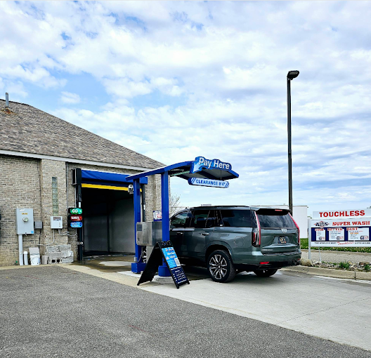 Cadillac Escalade pulling up to the Pay Here station at an Al's Super Wash touchless car wash