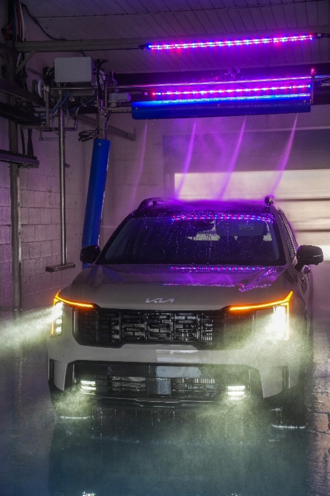 SUV inside an Al's Super Wash touchless bay with high-pressure water jets and LED lighting